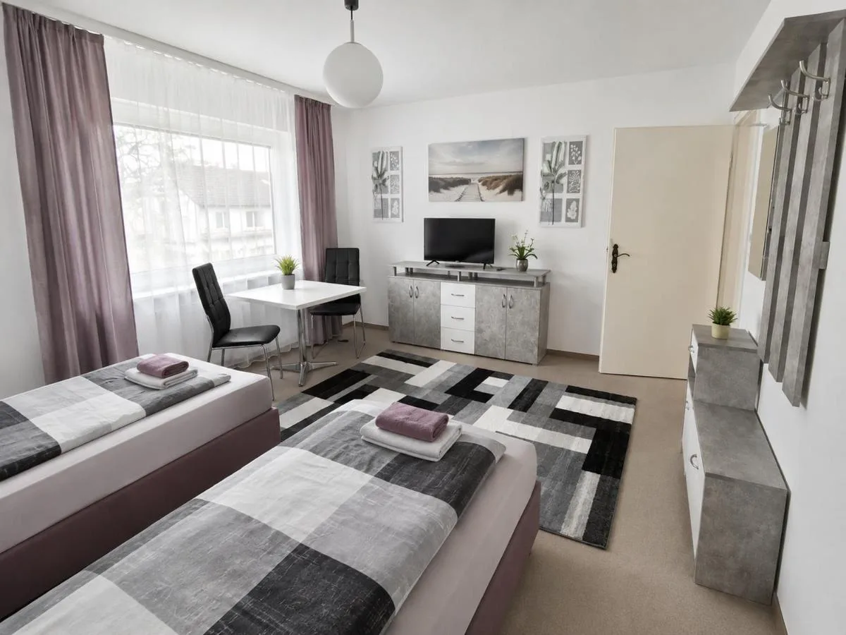 Helles Zimmer mit zwei Betten und Essplatz in den M&M Apartments Augustdorf