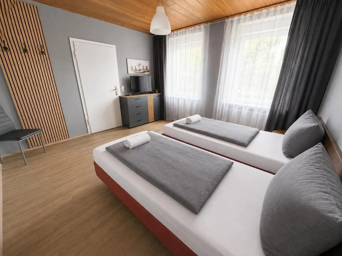 Zimmer mit Doppelbett und Holzverkleidung in den M&M Apartments Blomberg