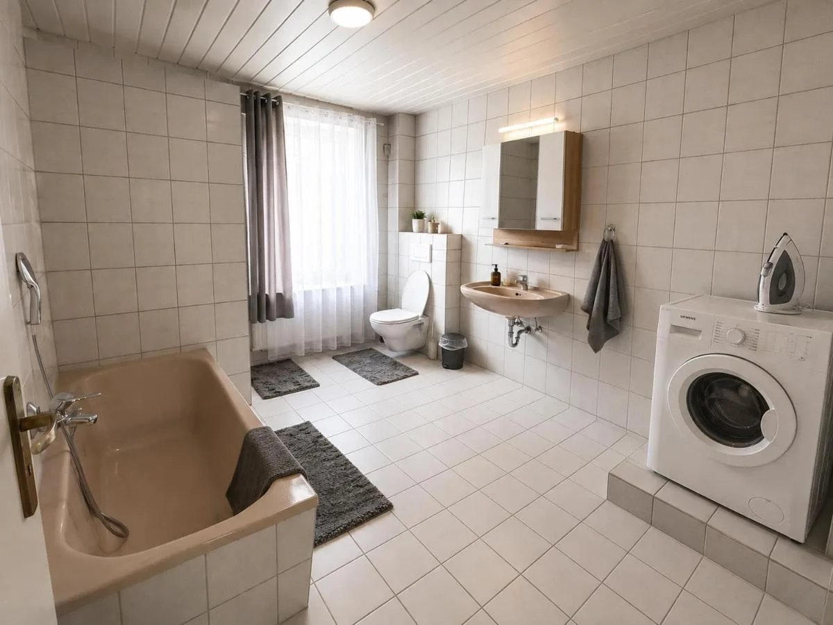 Badezimmer mit Badewanne und Waschmaschine in Blomberg