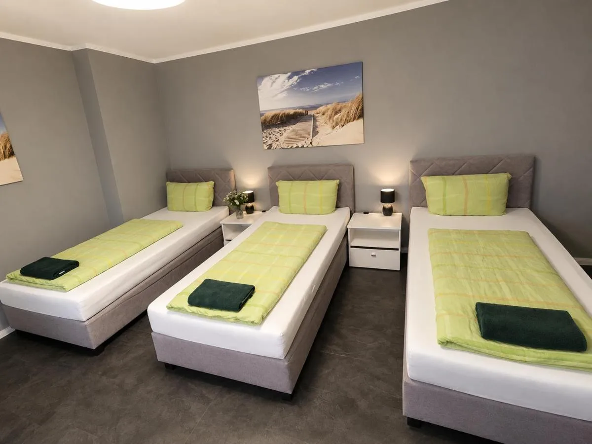 Schlafzimmer mit drei Einzelbetten im großen Apartment in Blomberg