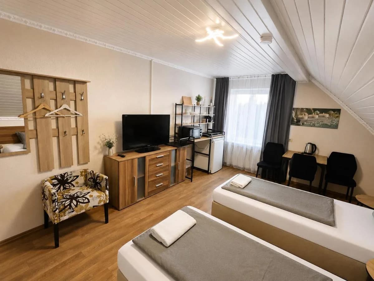Deluxe Zimmer mit Einzelbett, Fernseher und Sessel in Blomberg